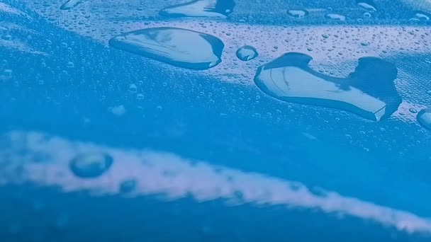 Wasser Auf Eine Glatte Oberfläche Streuen Tropfen Auf Das Blaue — Stockvideo