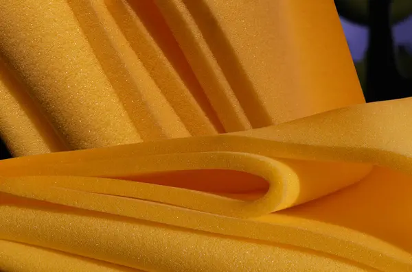 stock image a collection and pile of dark yellow sponge foam material in a room. folded industrial materials