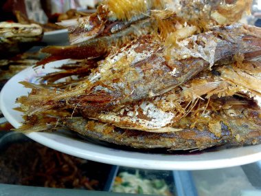 Beyaz cam tabakta kızartılmış tuzlanmış balık. Endonezya yemekleri