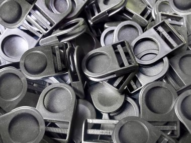 Siyah plastik kanca düğmeleri yığını. Bir dizi siyah kimlik kartı kancası ya da düğme. endüstriyel plastik durdurucu