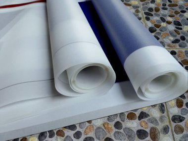 Odanın zeminine iki pankart asılmış. Mavi çizgili ince beyaz kumaş