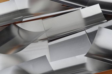 Tahta zeminin yüzeyinde alüminyum metal parçaları var.