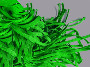 Gri arka planda bir grup parlak yeşil şerit. Ayakkabı bağcıkları ve kimlik kartları. Ögeler dikiliyor