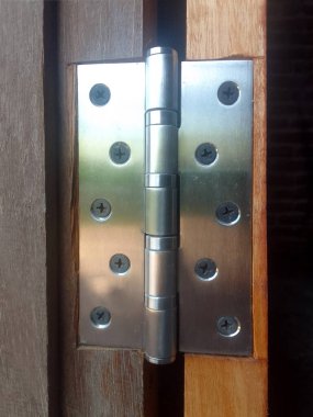 Paslanmaz çelikten yapılmış metal bir menteşe kapının kenarına bağlıdır.