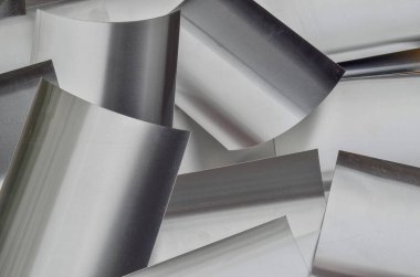 thin aluminum metal flakes scattered around. stacked curved pieces