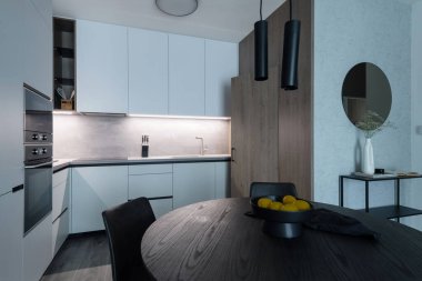 Kitchen with built in appliances and dining table of modern apartment