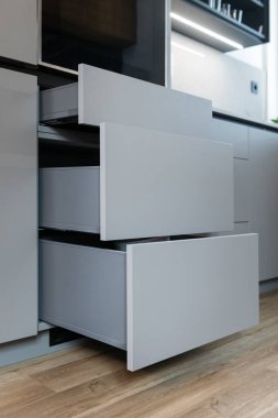 Detail of sliding shelves of cabinet in modern kitchen