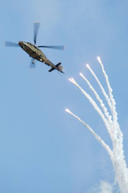 PAYERNE, SWITZERLAND - SEPTEMBER 6: Agusta A-109 releases flares on dynamic display at AIR14 airshow in Payerne, Switzerland on September 6, 2014