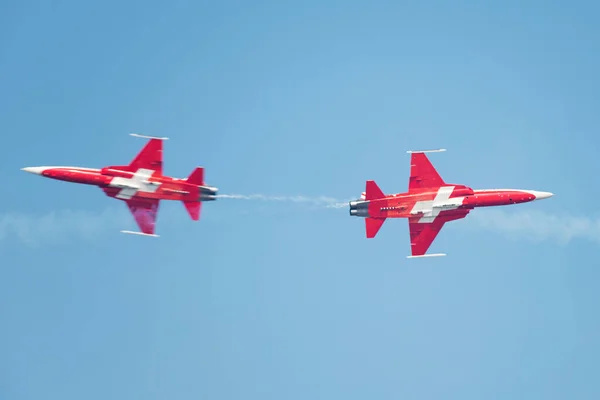 PAYERNE, SWITZERLAND - SEPTEMBER 6: Planes of Patrouille Suisse aerobatic team members are crossing in close distance on AIR14 airshow in Payerne, Switzerland on September 6, 2014