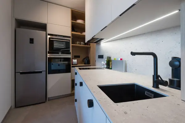 Kitchen with built in appliances of small urban apartment