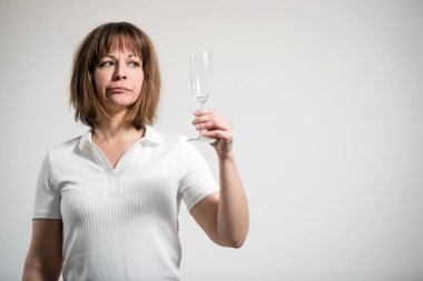 Beyaz arka planda boş şampanya kadehi tutan beyaz bir kadın. Kuru Meydan Okuma 'nın kavramsal resmi.