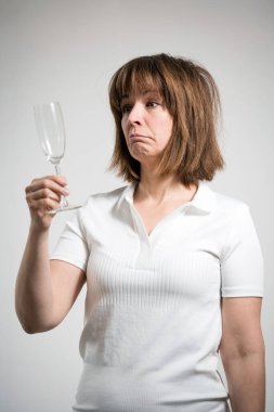 Beyaz arka planda boş şampanya bardağına bakan beyaz bir kadın. Kuru Meydan Okuma 'nın kavramsal resmi. 