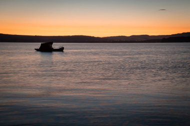 Fishing boat on Liptovska Mara dam in morning light, Liptov region, Slovakia clipart