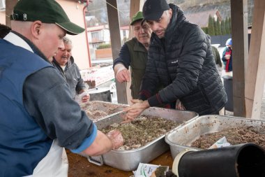 BANSKA BELA, SLOVAKIA - MAR 1, 2025: İnsanlar Slovakya 'nın Banska Bela kentinde düzenlenen ev yapımı sosisler için domuz eti işliyorlar