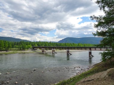 Dağlardaki bir nehrin üzerinde, seyrek nüfuslu bir bölgede eski bir ahşap köprü..