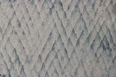 Dalgalar alçaldığında kumlu bir sahil dokusu. Tasarım için alışılmadık arkaplan.