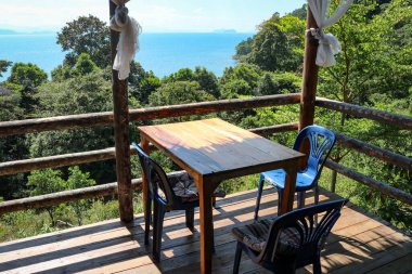 Tropik bir adada ahşap terası olan bir kafe. Deniz manzaralı. Seyahat, rahatlama, tatil kavramı.