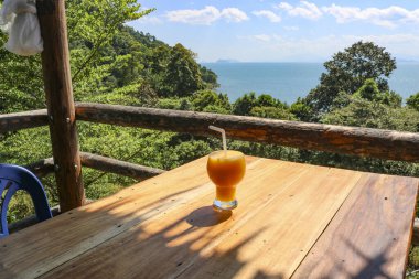 Denize bakan bir kafede mango kokteyli. Rahatlama, tatil, sağlıklı yaşam tarzı, seyahat kavramı..