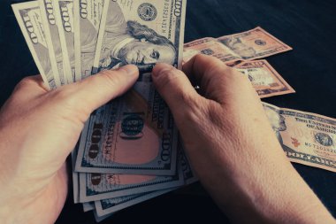 Elde dolar, para sayma. Finans ve ekonomi kavramı. Seçici odaklanma. Vintage renklendirmesi.