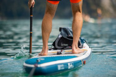 Şişirilebilir SUP Stand-Up Paddle tahtasıyla kürek çeken adam
