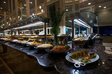 Her şeyi kapsayan lüks bir otelin masasında güzel bir şekilde düzenlenmiş çeşitli yemek ve atıştırmalıklar. Gıda, seyahat ve lüks tasarımlarda kullanmak için mükemmel.