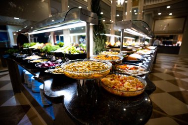 Her şeyi kapsayan lüks bir otelin masasında güzel bir şekilde düzenlenmiş çeşitli yemek ve atıştırmalıklar. Gıda, seyahat ve lüks tasarımlarda kullanmak için mükemmel.