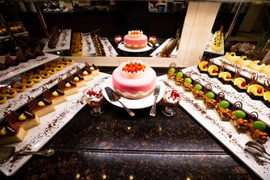 Pasta, pasta ve Türk tatlıları da dahil olmak üzere çeşitli tatlılar her şeyi kapsayan lüks bir otelin masasında güzelce düzenlenmiştir. Gıda, seyahat ve lüks tasarımlarda kullanmak için mükemmel