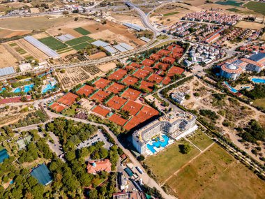 Birçok tenis kortunun havadan görünüşü, profesyonel bir tenis tesisinin uçsuz bucaksız genişliğini ve organizasyonunu gösteriyor.