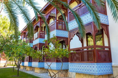 Bahçesinde bereketli palmiye ağaçları olan lüks bir otel, tropikal zerafet ve rahatlama sergiliyor