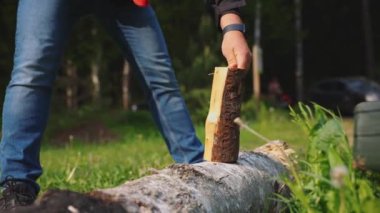 Ormandaki yong erkeği çelik baltayla odunları doğruyor.