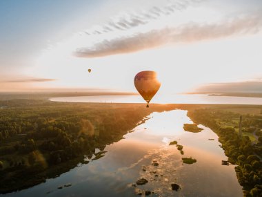 Sıcak hava balonu gün doğumunda ya da günbatımında uçuyor. Hava aracı görünümü