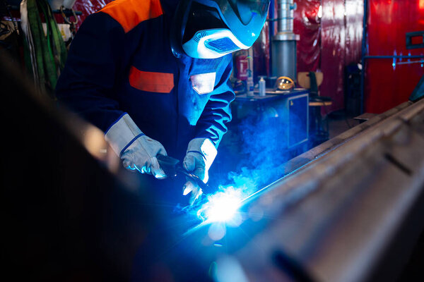 Metal welding steel works using electric arc welding machine to weld steel at factory. Metalwork manufacturing and construction maintenance service by manual skill labor concept.