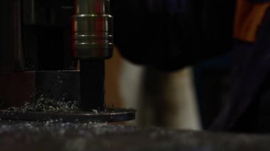 Delme işlemine yakın çekim, matkap etrafındaki metal talaşları. Bulanık arkaplan