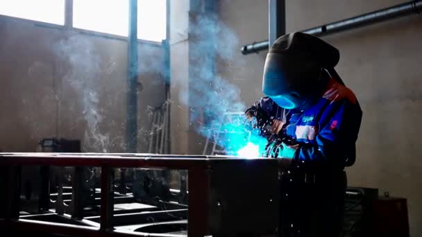 安全装置を身に着けている間工場でアーク溶接機で働く熟練した金属労働者 手作業による金属加工製造 施工保守サービスの概念 — ストック動画