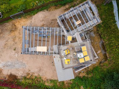 Ormanlık alanda beton blokları ve inşaat malzemeleri olan yeni bir ev inşa ediliyor.