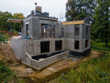 Açık tuğla duvarları ve ahşap kirişleri olan bir banliyö evi şantiyesinde ilerleme