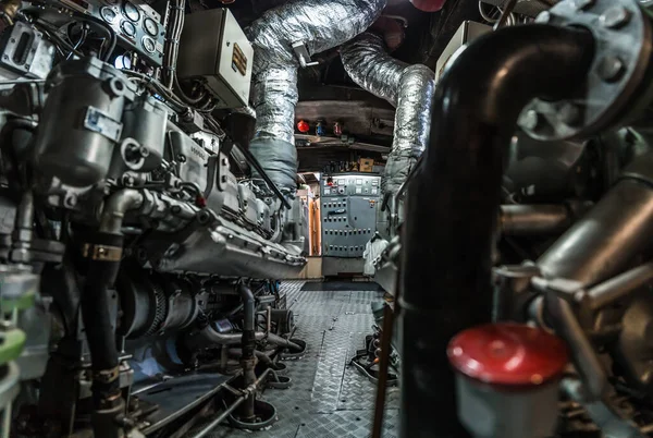 Complex interior of a ship\'s engine room with machinery and metal piping
