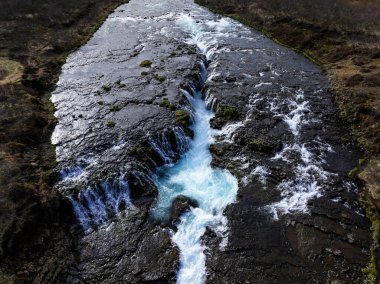 Bruarfoss Şelalesi 'nin havadan görünüşü, İzlanda' nın en mavi şelalesi taşların üzerinden akan canlı mavi su. İzlanda 'nın en ünlü yeri.