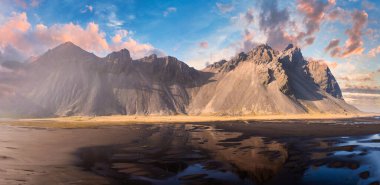 İzlanda, Stoksnes Yarımadası 'ndaki Vestrahorn Dağı' nın dramatik tepeleri ve siyah kum tepeleri üzerinde çarpıcı bir gün batımı..