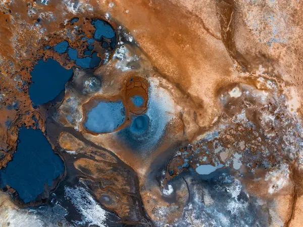 Stock image Aerial view of Hverir Geothermal Area, Iceland, showcasing vibrant blue and orange geothermal pools and mud pits in a surreal landscape.