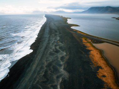Okyanus dalgalarının bir tarafa çarptığı İzlanda 'nın göz kamaştırıcı siyah kumsal manzarası ve diğer tarafta dingin bir lagün dramatik doğal manzarayı gözler önüne seriyor..