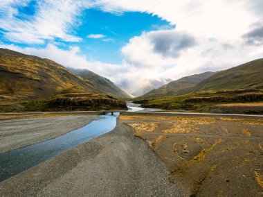 Engebeli tepeler ve puslu dağlarla çevrili bir vadiden geçen İzlanda nehrinin çarpıcı hava manzarası İzlanda 'nın saf güzelliğini ve huzurlu manzarasını yakalıyor..