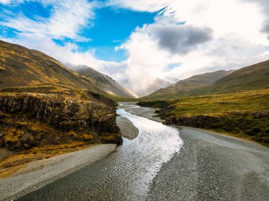 Engebeli tepeler ve puslu dağlarla çevrili bir vadiden geçen İzlanda nehrinin çarpıcı hava manzarası İzlanda 'nın saf güzelliğini ve huzurlu manzarasını yakalıyor..