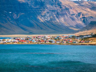 İzlanda 'nın görkemli dağlarına yuva yapmış renkli evleri olan büyüleyici sahil kasabası.