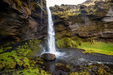 İzlanda 'daki Kvernufoss şelalesinde yemyeşil, engebeli uçurumlar, kıvrımlı bir patika ve çağlayan bir şelale bulunur.