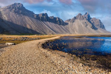 Gün batımında İzlanda, Stokksnes Burnu 'ndaki Vestrahorn Dağı' nda. İnanılmaz İzlanda manzarası ve deniz manzarası. Popüler turistik cazibe.