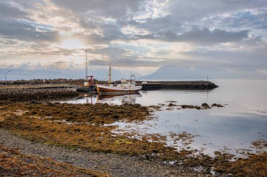 İzlanda 'da gün batımında balıkçı teknesi olan sahili.