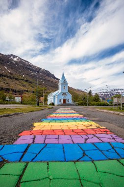 Seydisfjordur 'daki ünlü gökkuşağı yolu. Etrafında İzlanda binaları var. Sanat eserleri boyalı duvarlar. İzlanda 'nın Seydisfjordur kasabası.