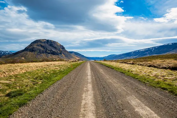 stock image Endless gravel road leading to a stunning mountainous landscape in rural Iceland