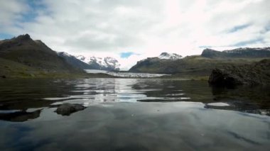 İzlanda 'da gün batımında Svinafelljokull buzulu ve buzul gölünün canlı gökyüzü manzarası nefes kesici.